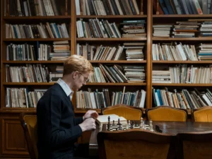 mężczyzna-znajdujący-się-w-blibliotece-planuje-kolejny-ruch-w-szachy-strategia